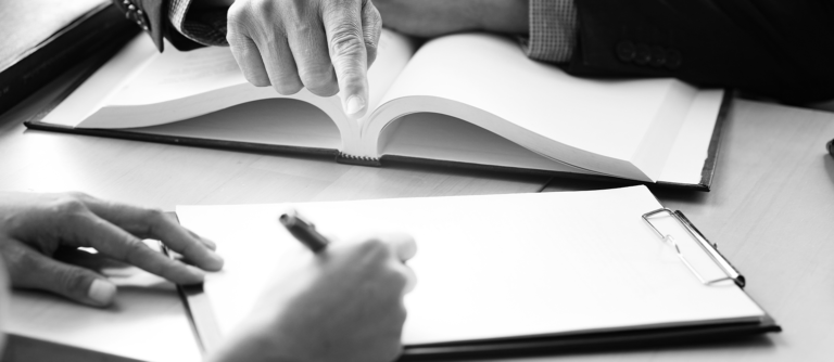 Duas pessoas escrevendo em um caderno.