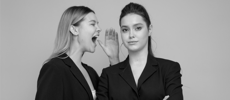 Foto preto e branco de mulher gritando com outra mulher no trabalho
