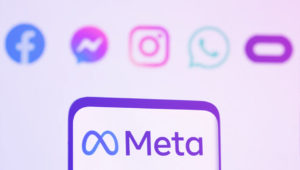 Celular com o logo Meta e como background os logos do grupo meta